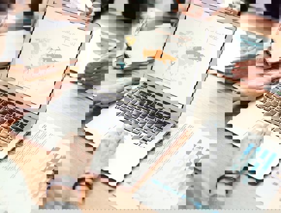 Person looking at world map on their laptop screen.