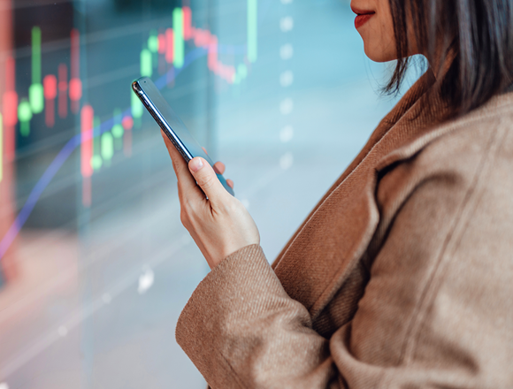 Women in brown jacket looking at her phone.