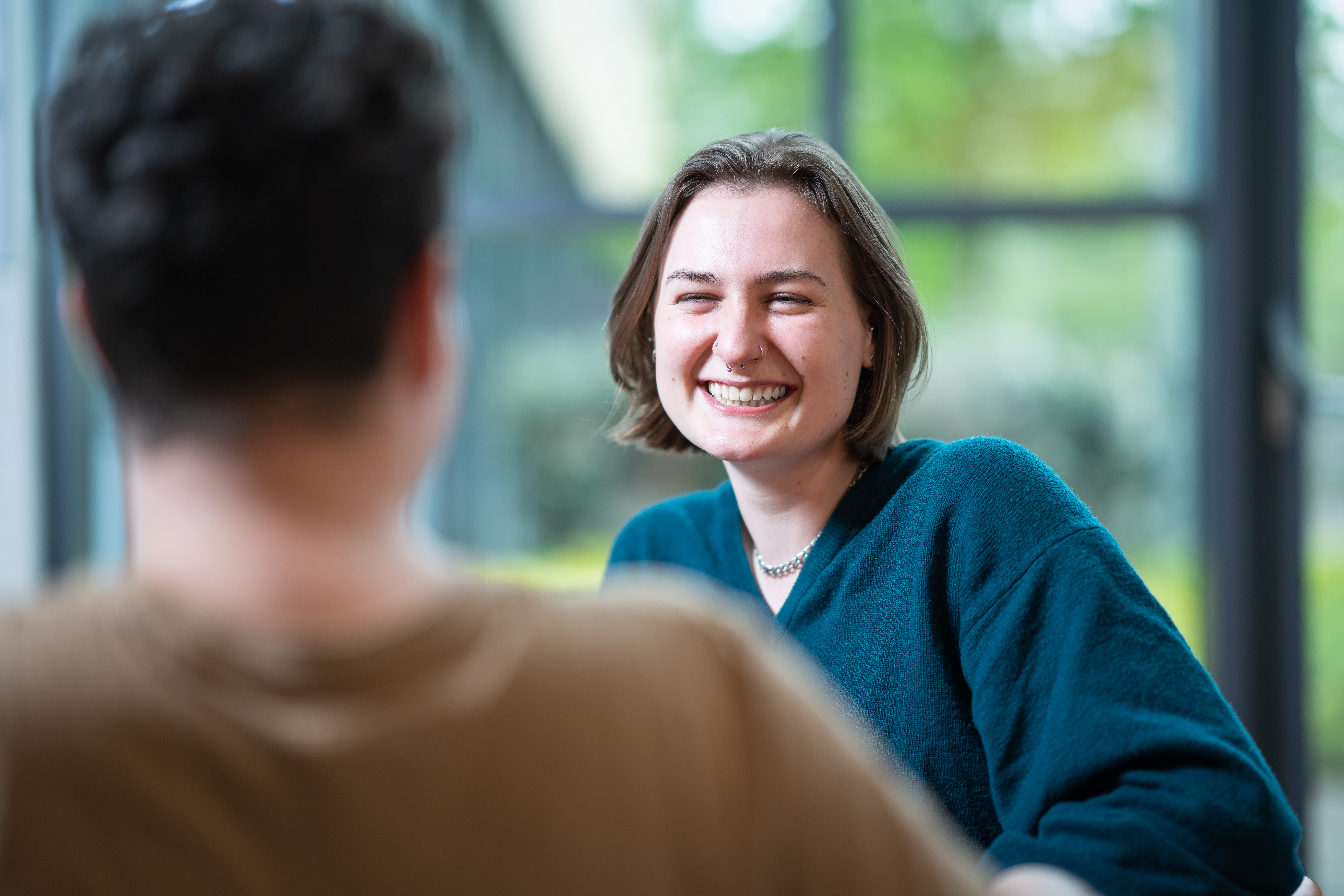 Girl and boy laughing together at an Edinburgh College campus.