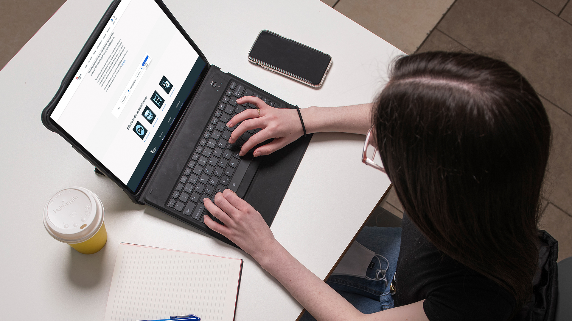Student from above looking at the funding tool page on their laptop.