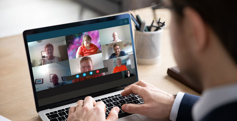 Business man wearing a suit is on a conference call on their laptop.