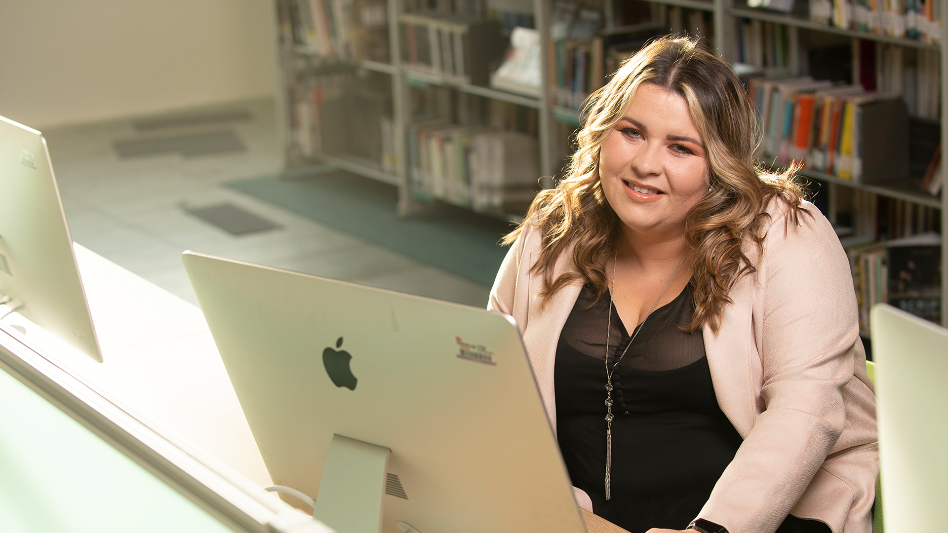 Student working at a desktop computer in the library.