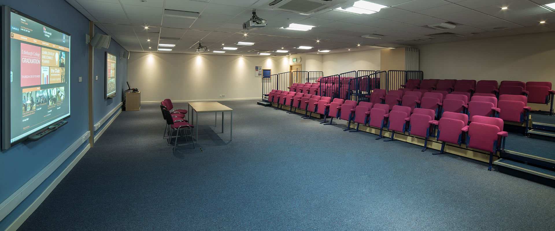 Lecture theatre at Edinburgh College with tiered seating and a large screen on the wall.